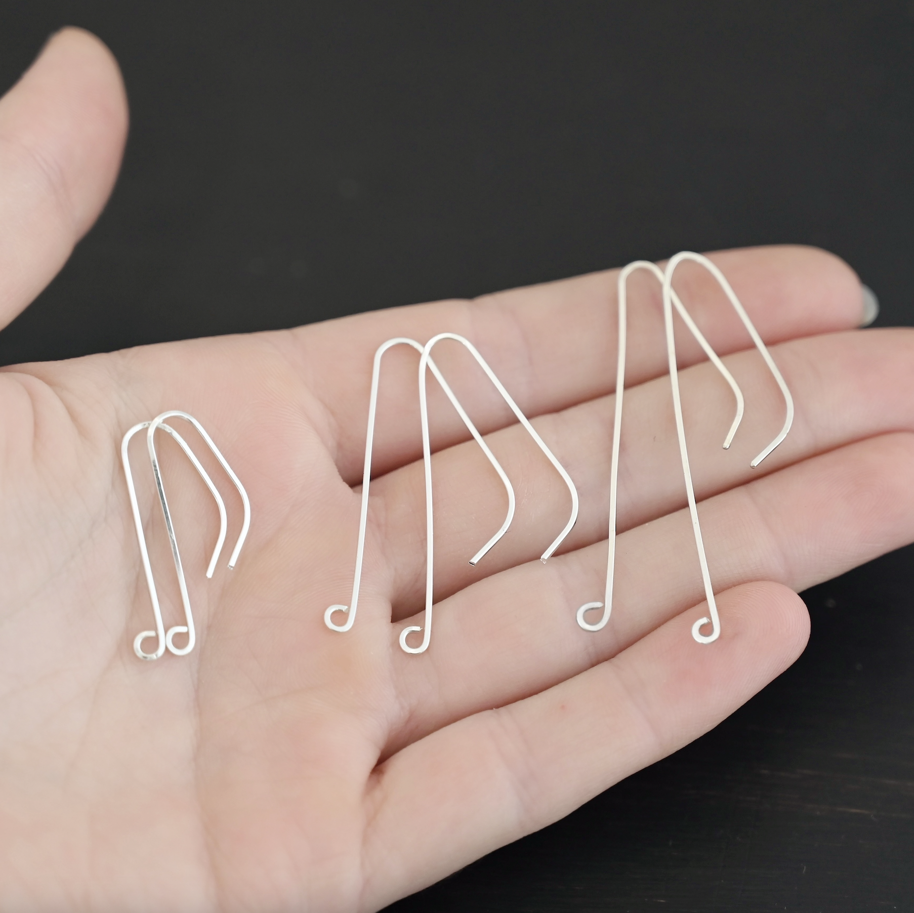 sterling silver Whimsical Ear Wire - shiny all sizes shown in hand